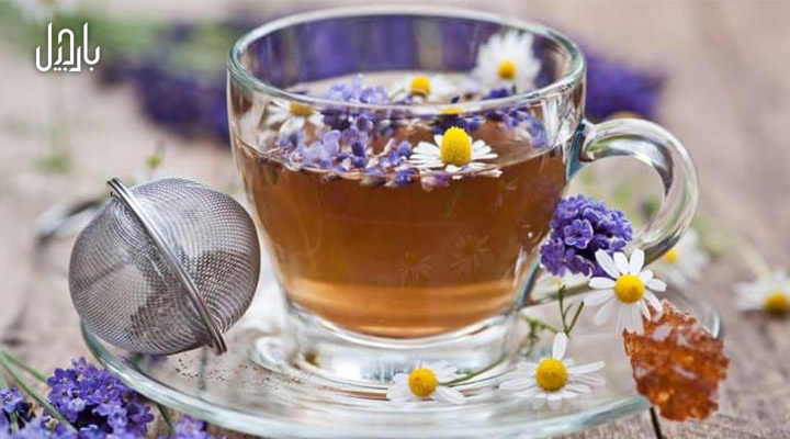 یک فنجان دمنوش اسطوخودوس با تزئین گل‌های بابونه