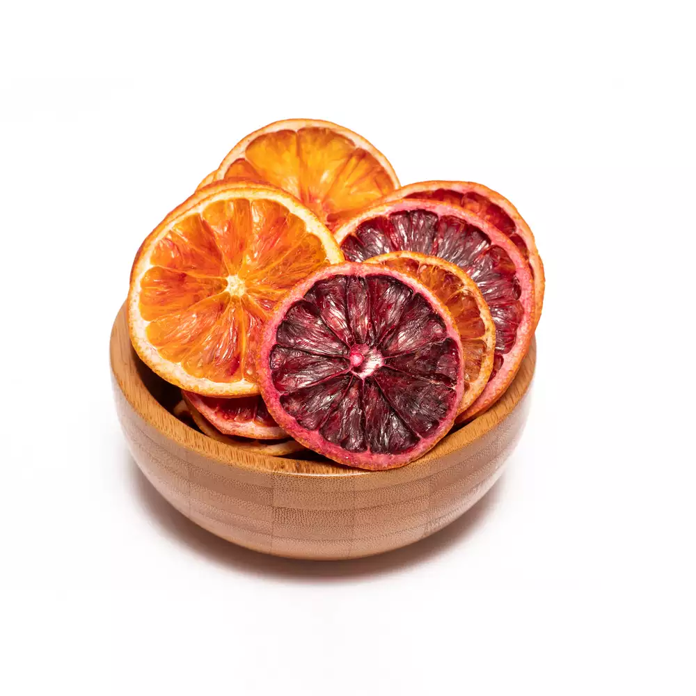 یک کاسه چوبی شامل مقداری پرتقال خونی خشک با پیش زمینه سفید