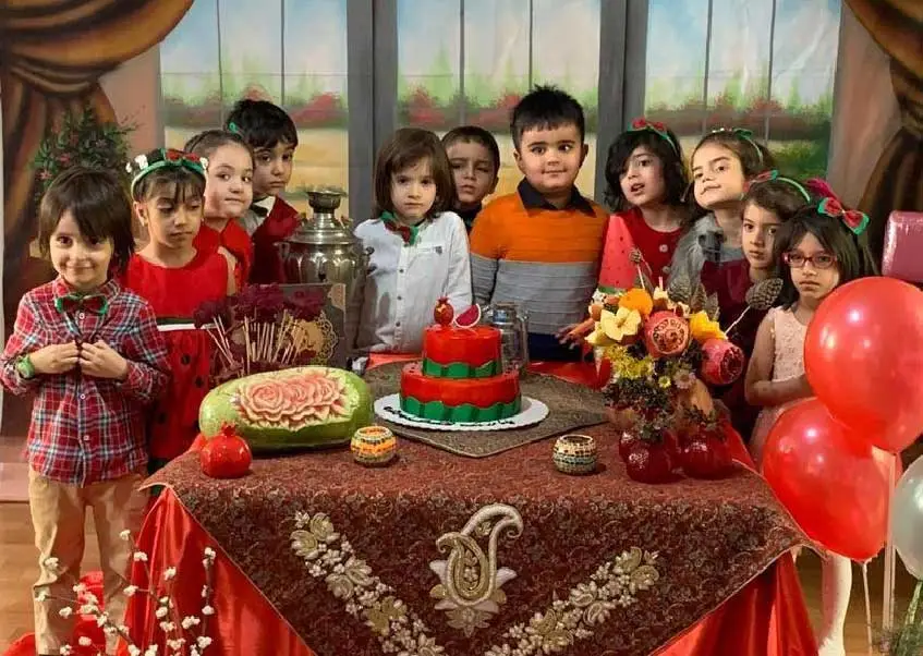 کودکان دور میز در جشن یلدای مهدکودک