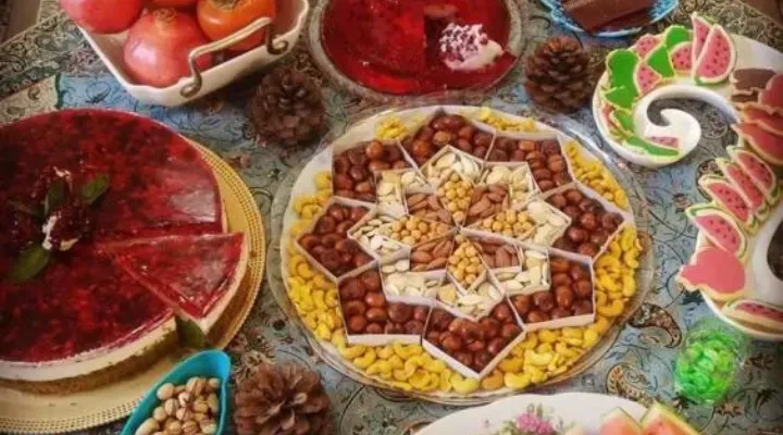 سفره یلدای تزئین شده با کیک، آجیل، ژله و میوه