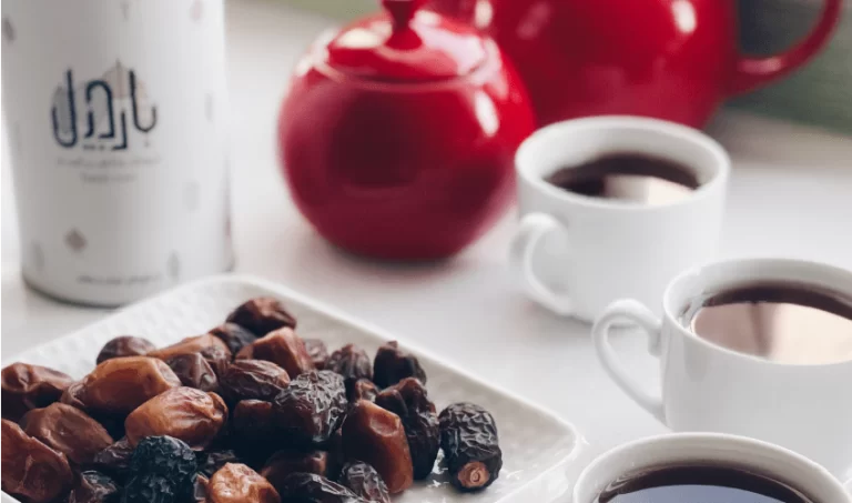 چند خرمای مجول با دو فنجای چای دو قوری قرمز و قوطی مقوایی بارجیل