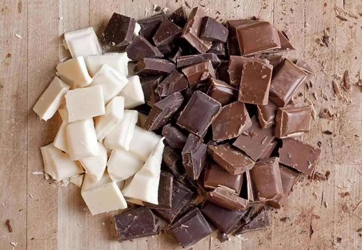 مقداری شکلات تلخ، شیری و سفید روی میز