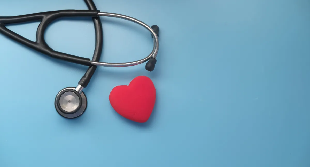 یک قلب قرمز فانتزی و گوشی پزشکی روی زمینه آبی رنگ
