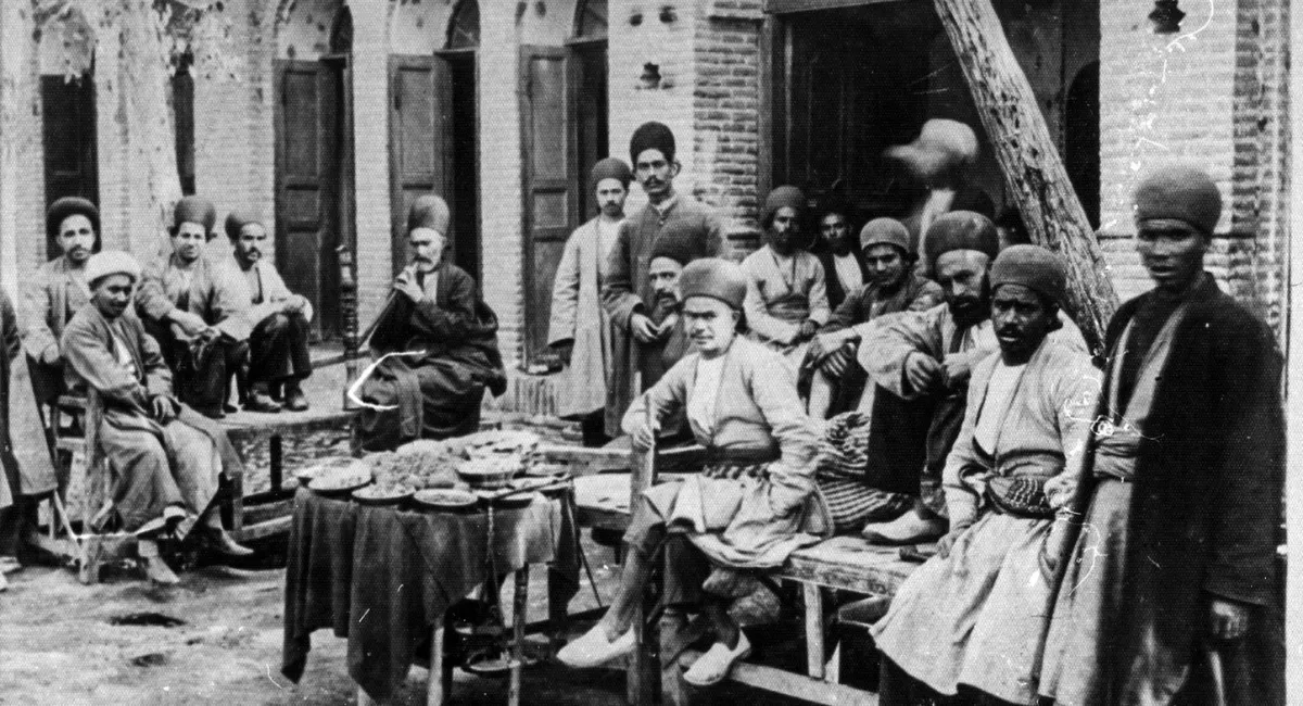 عکسی از قهوه خانه قدیمی ایرانی و مردان در حال نوشیدن قهوه و قلیان کشیدن