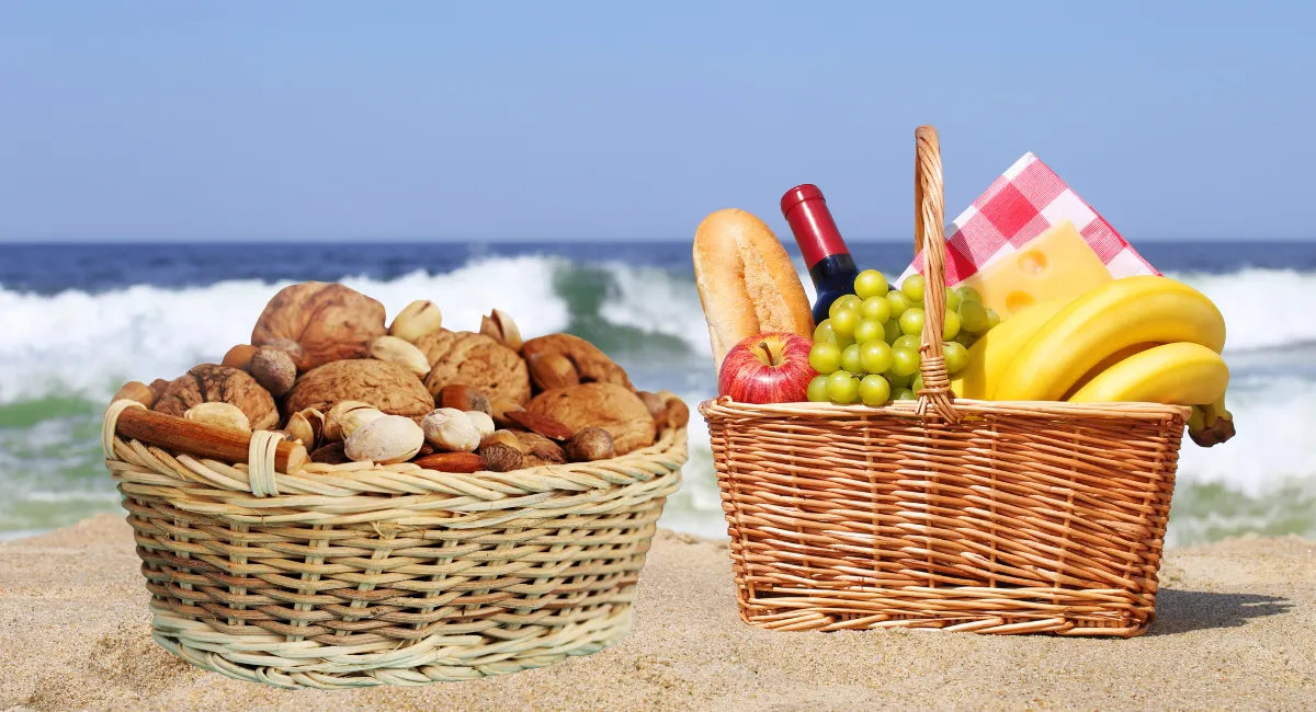 یک سبد آجیل و یک سبد میوه در کنار ساحل