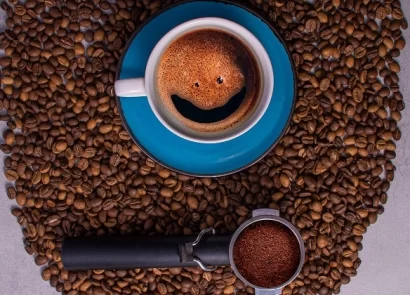یک فنجان قهوه با چند دانه قهوه