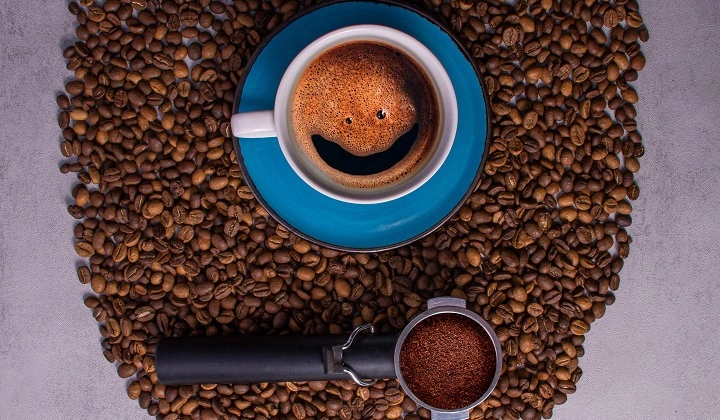 یک فنجان قهوه با چند دانه قهوه
