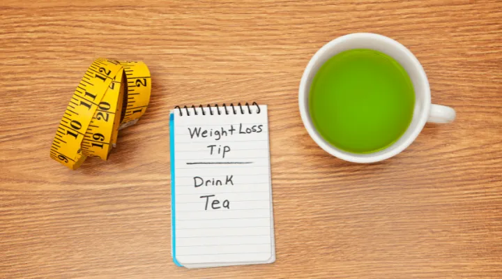 یک متر، دفترچه با نوشته انگلیسی کاهش وزن، یک فنجان چای سبز
