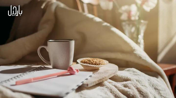 یک لیوان قهوه بر روی تخت در صبح