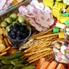 سینی مزه پر از شیرینی، میوه، کالباس، سبزیجات، آجیل