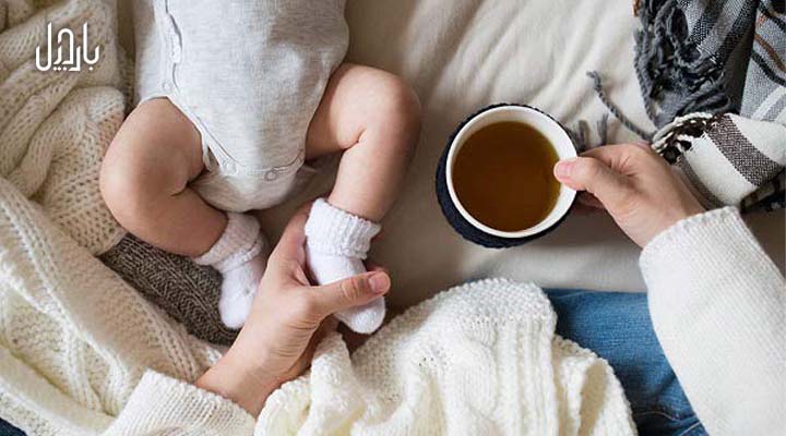 مادر و نوزاد و یک لیوان دمنوش روی تخت