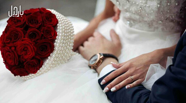 یک عروس و داماد در حال گرفتن دست های همدیگر