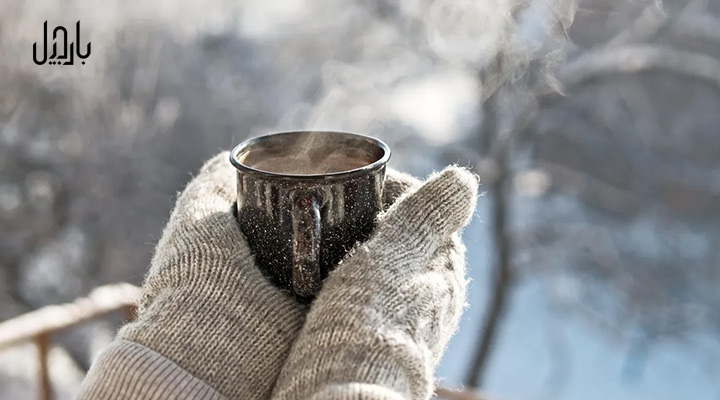 یک لیوان نوشیدنی داغ در هوای سرد برفی