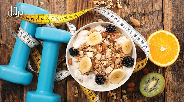 یک کاسه اوت میل جو دوسر در کنار متر و دمبل ورزشی